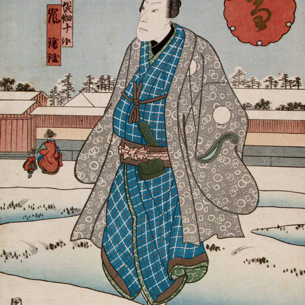 This Photo depicts a wealthy Japanese samurai. He is seen standing in a snow covered field outside of what looks to be a town. He is earing a blue checkerboard robe with a brown tie around his chest. A brown and red sash is around his waist. You can see the green hilt of what could be assumed to be his katana. he is also wearing a grey kimono with various shapes dotted within it.